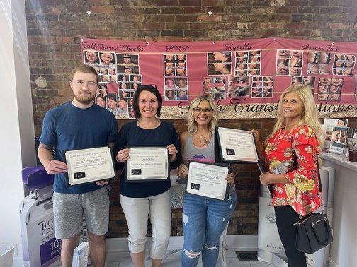 a group of people are standing next to each other holding certificates at ERA Wellness Spa