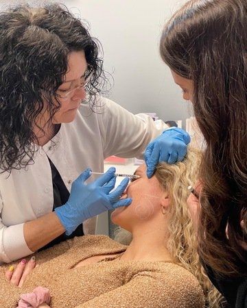 a woman is getting a botox injection in her face .