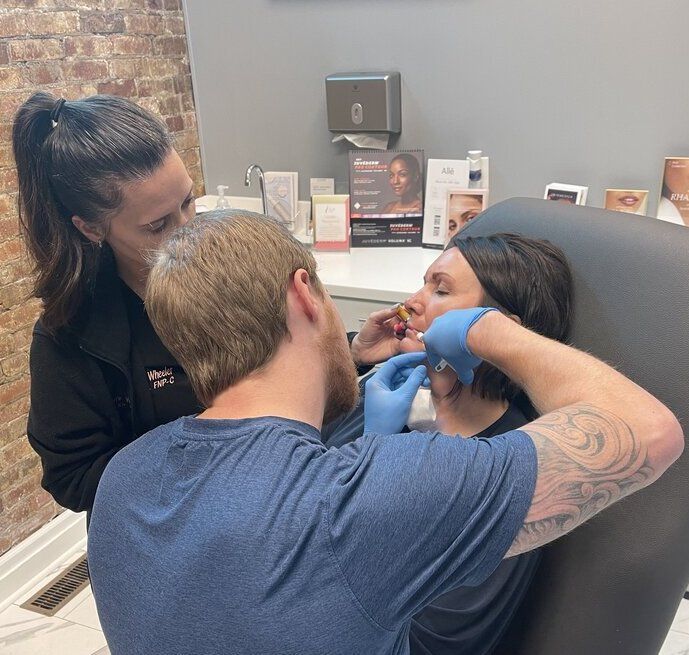 a woman is getting a botox injection while a man watches at ERA Wellness Spa