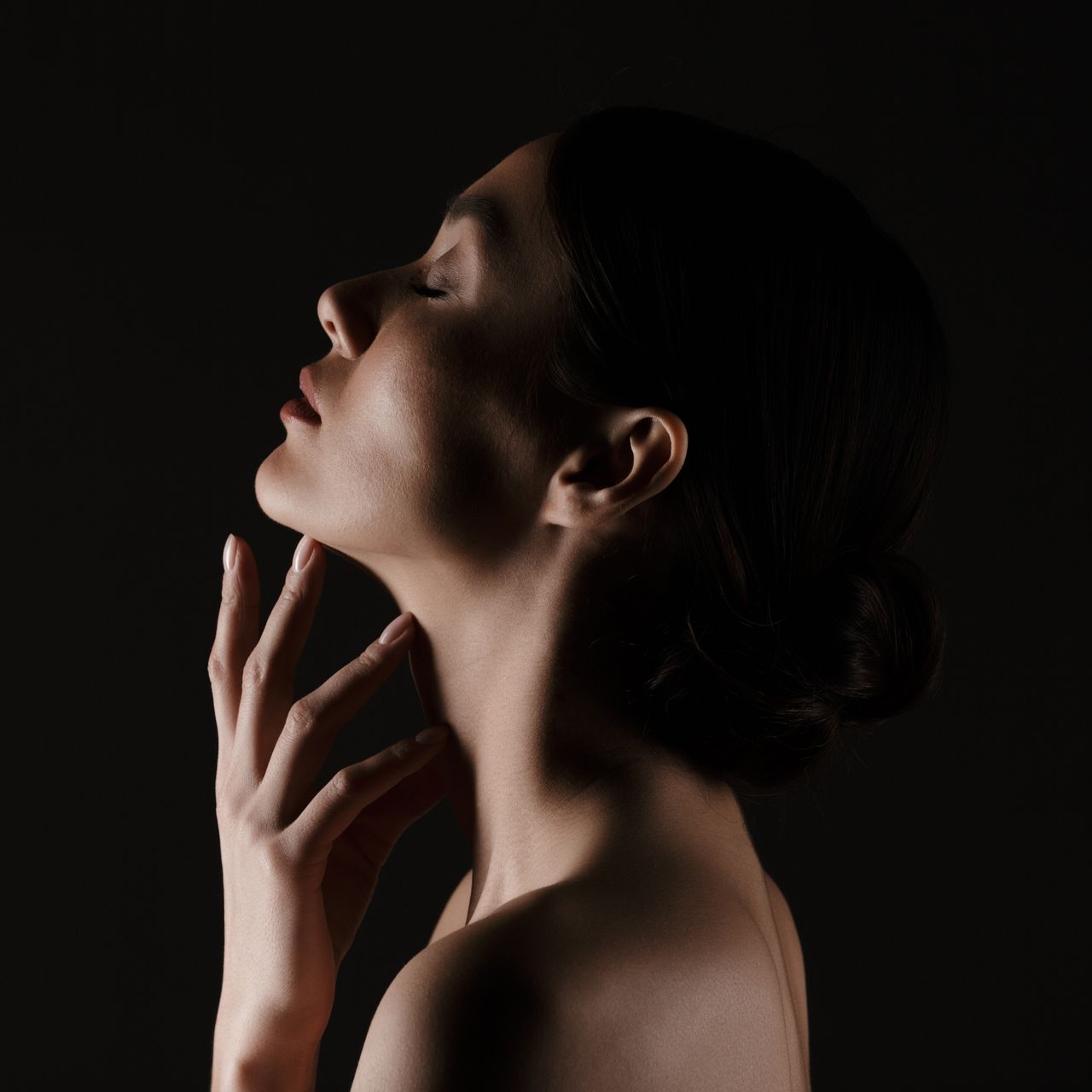 a woman with her eyes closed touches her neck with her hand at ERA Wellness Spa in Georgetown