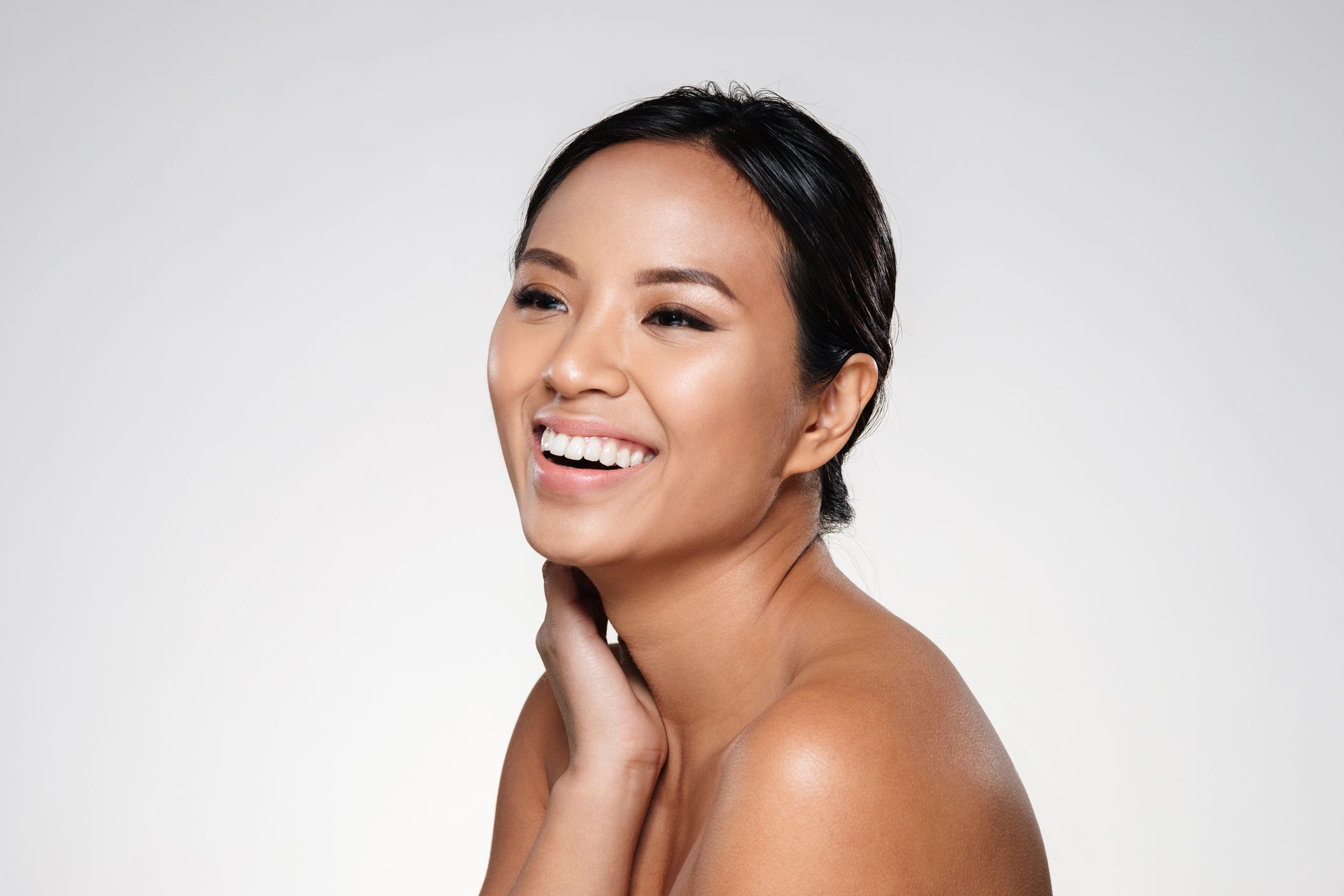 a woman without a shirt is smiling with her hand on her neck at ERA Wellness Spa in Georgetown, KY