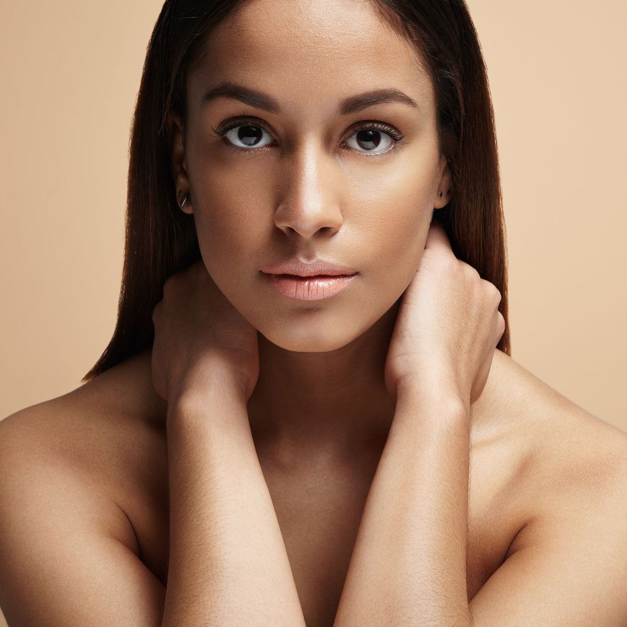 a woman with her hands on her neck looks at the camera at ERA Wellness Spa