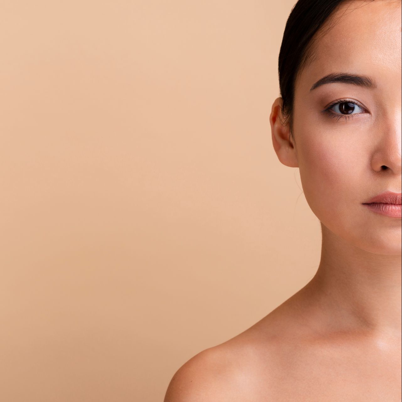 half of a woman 's face is shown against a beige background at ERA Wellness Spa