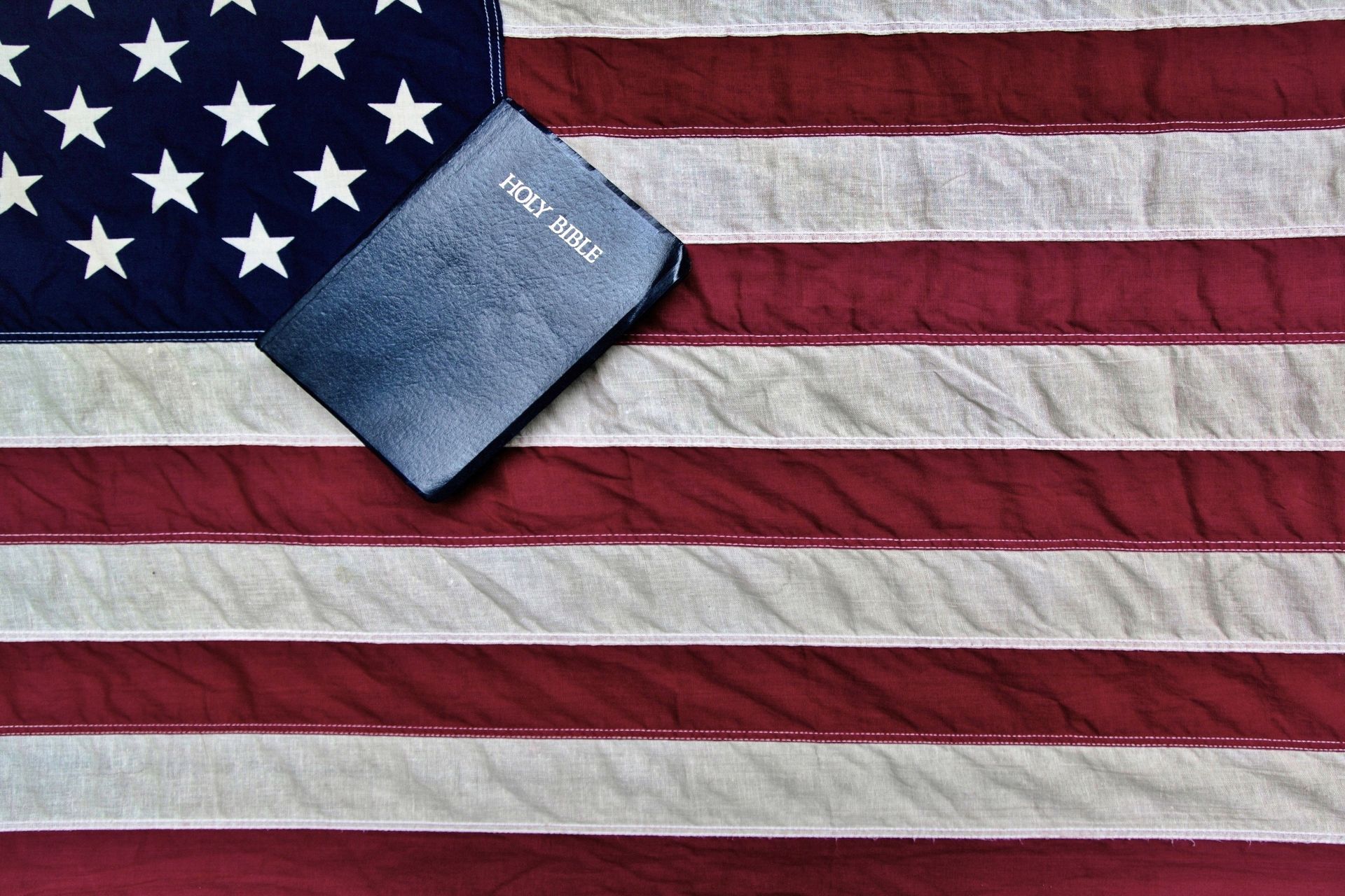 An american flag with a bible on top of it