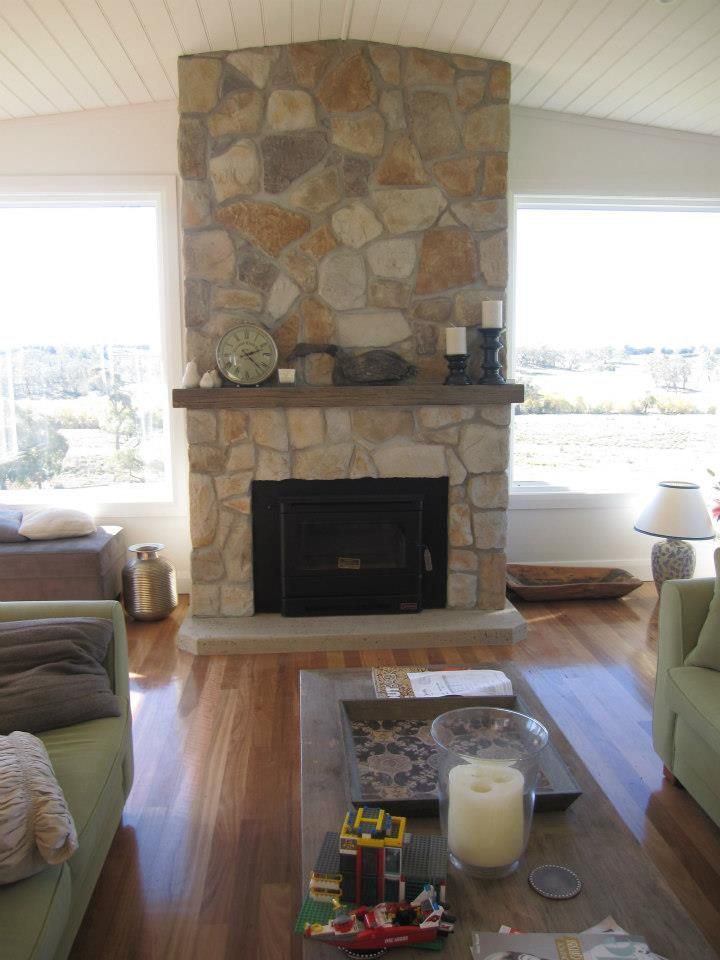 A living room with a stone fireplace and a couch