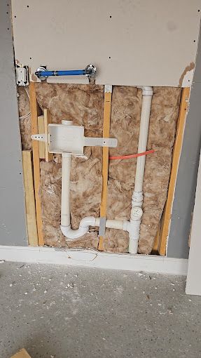 A close up of a wall with pipes coming out of it.