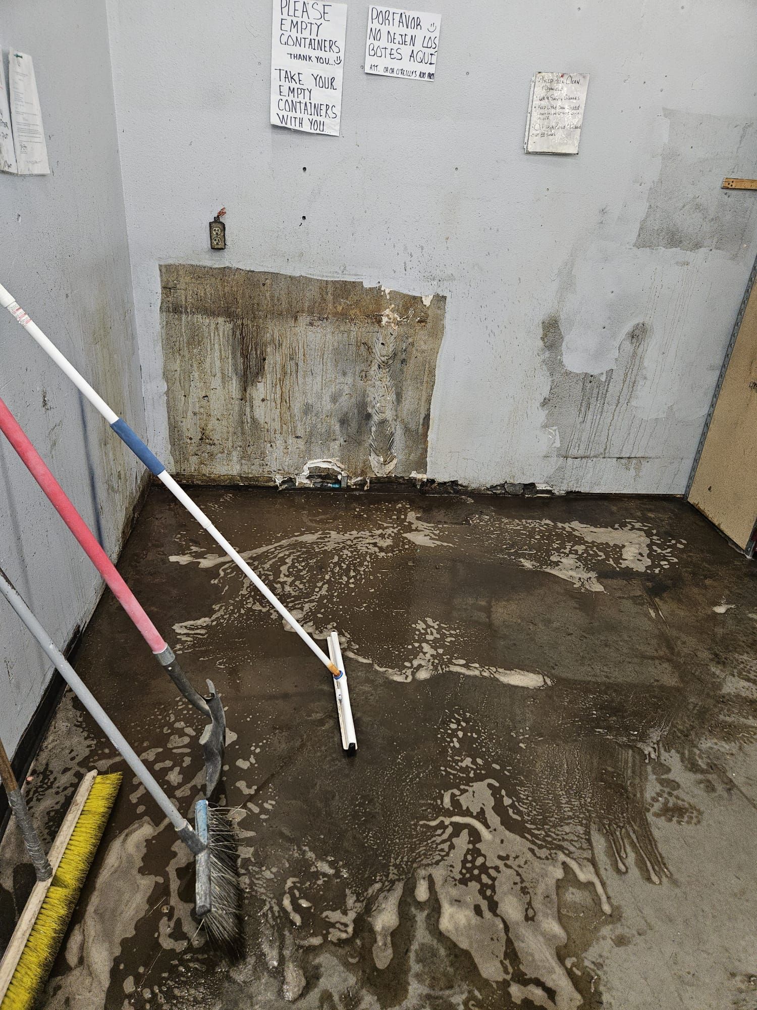 A room with a mop and broom on the floor.