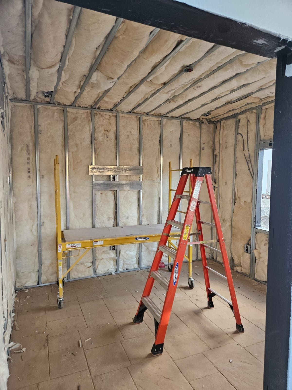 A room with a ladder and a scaffolding in it.