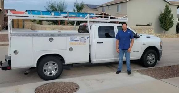 A man is standing in front of a white truck.