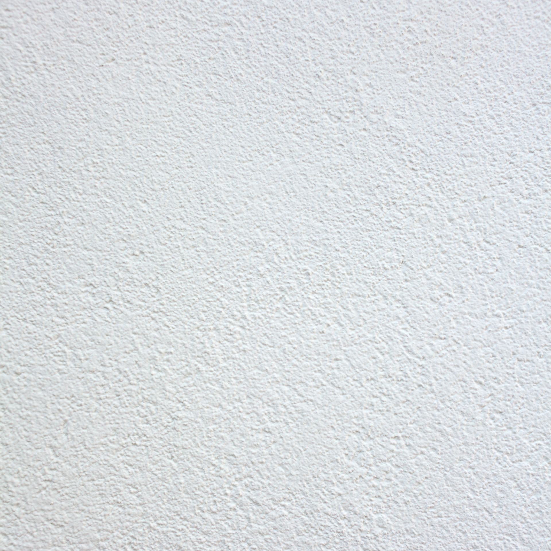 An empty room with buckets of paint on the floor.