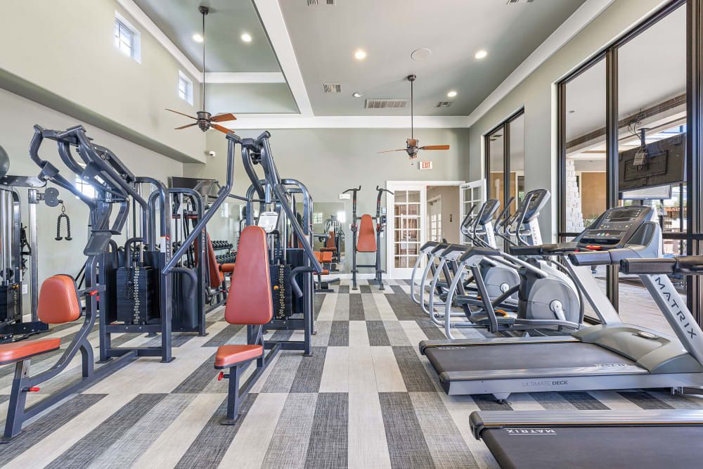 A large gym with a lot of exercise equipment and treadmills at Marquis at The Woodlands in Spring, TX.