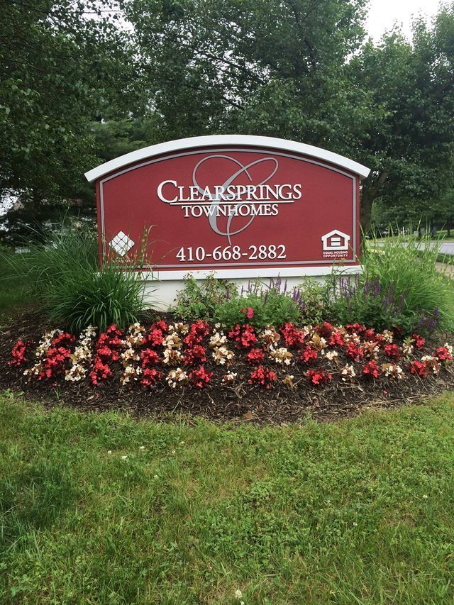 Landscape maintenance services at a residential community entrance with seasonal flower care.