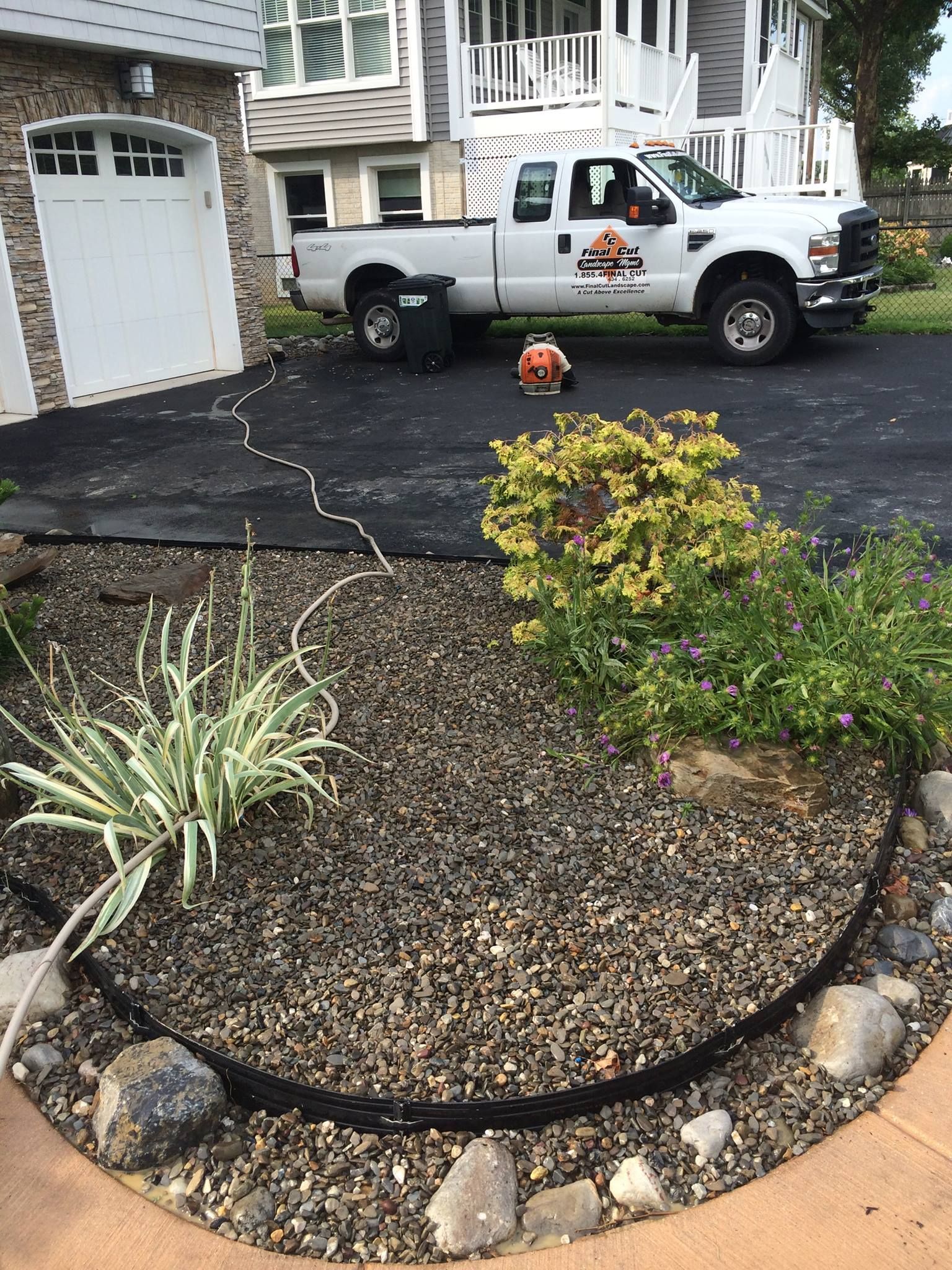 Landscape work in progress with truck, blower, and mulch.