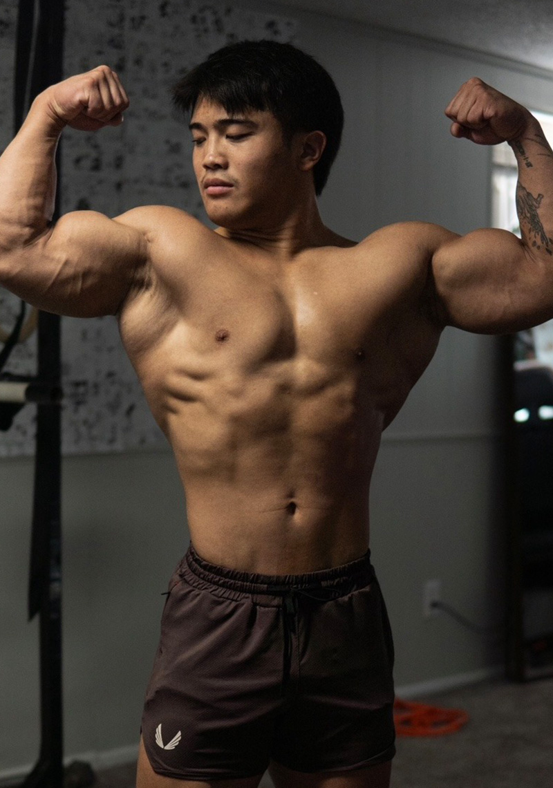 Manni kumar  is lifting a barbell in a gym.