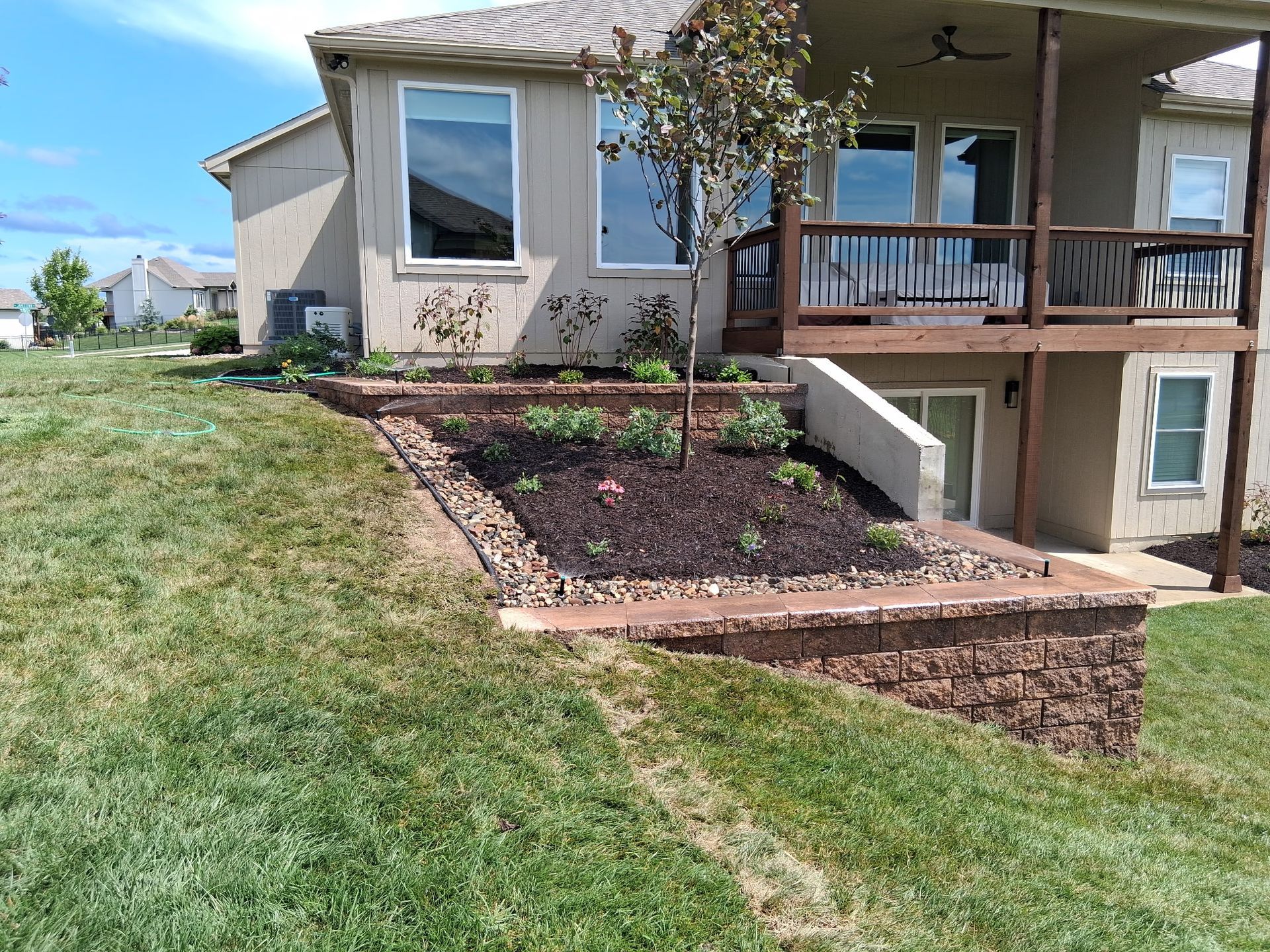Backyard landscaping with retaining walls and a planted garden.