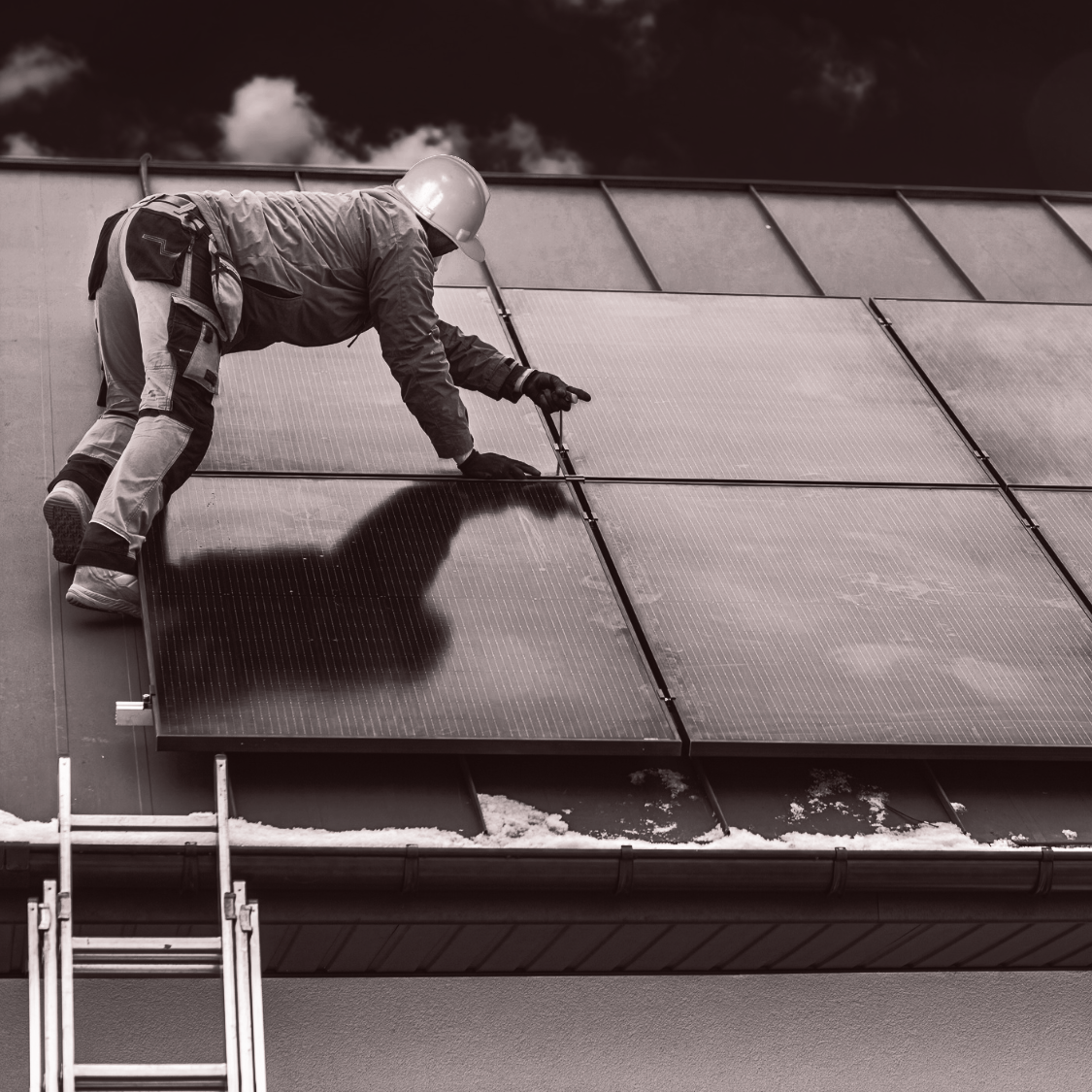 A man is installing solar panels on the roof of a building