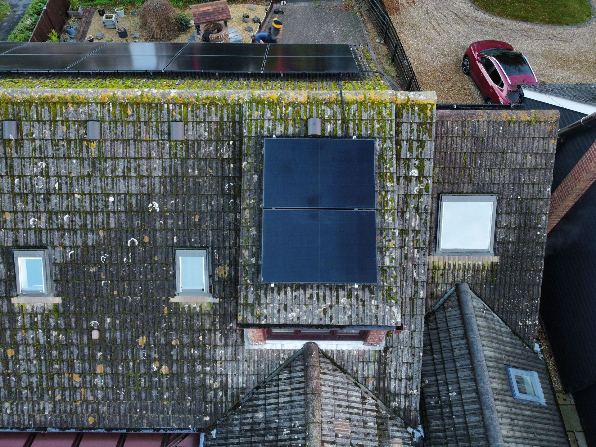 An aerial view of a house with solar panels on the roof.