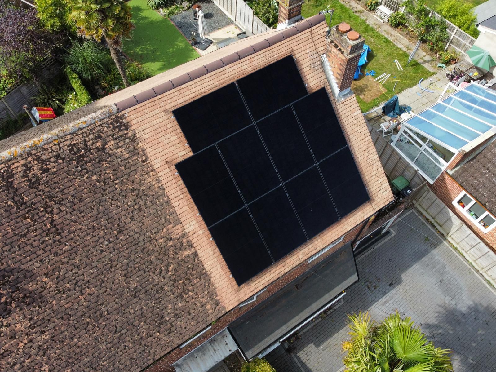 An aerial view of a house with solar panels on the roof.
