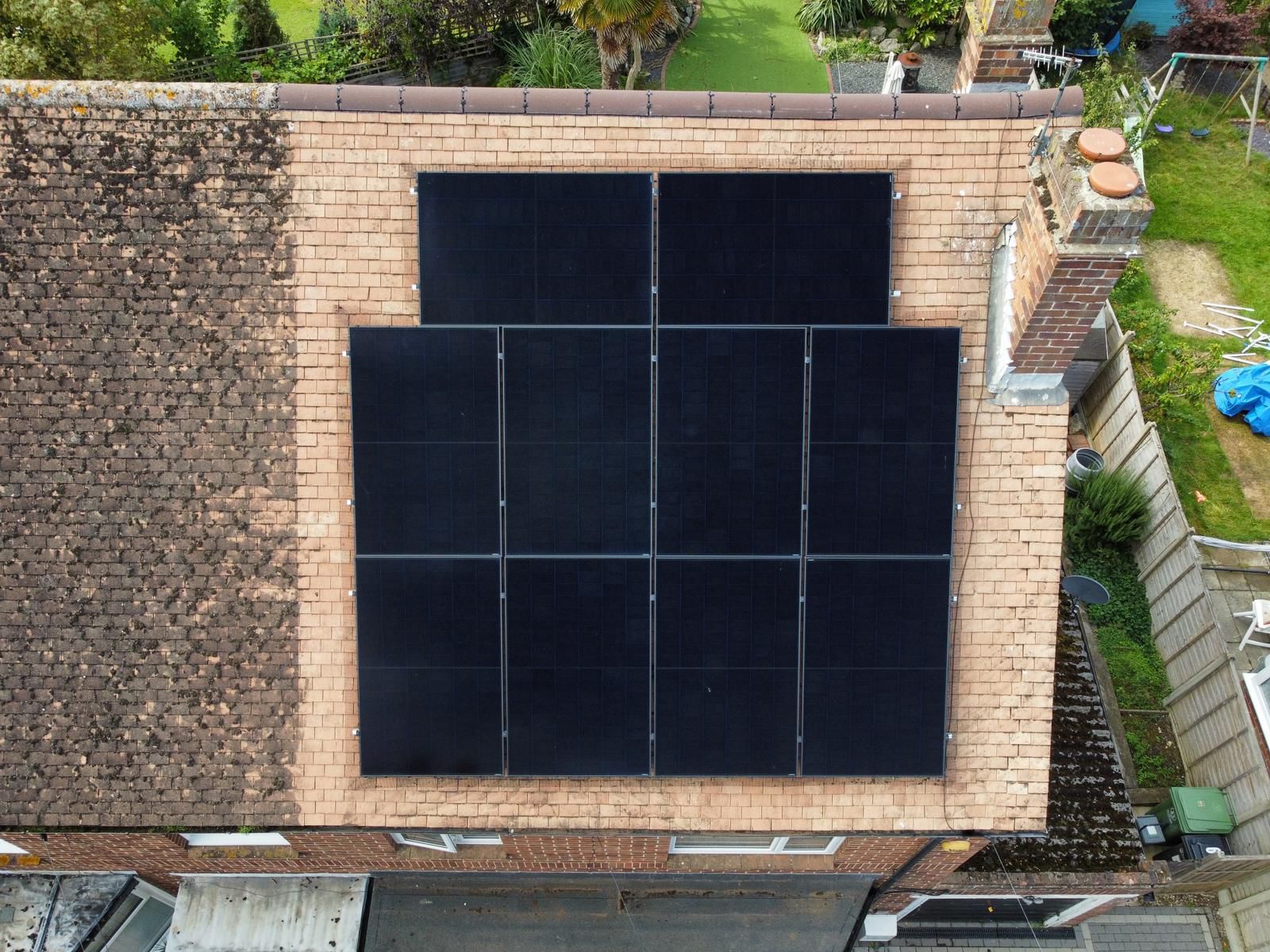 An aerial view of a house with solar panels on the roof