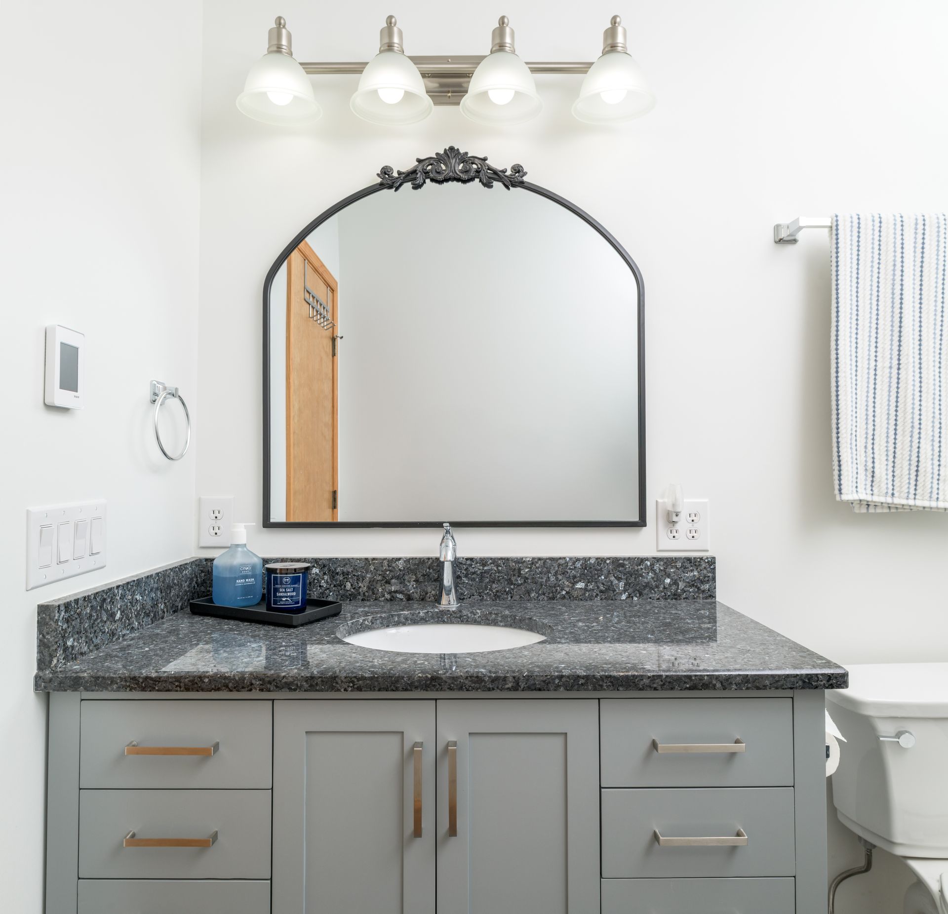 A bathroom with a sink a mirror and a toilet