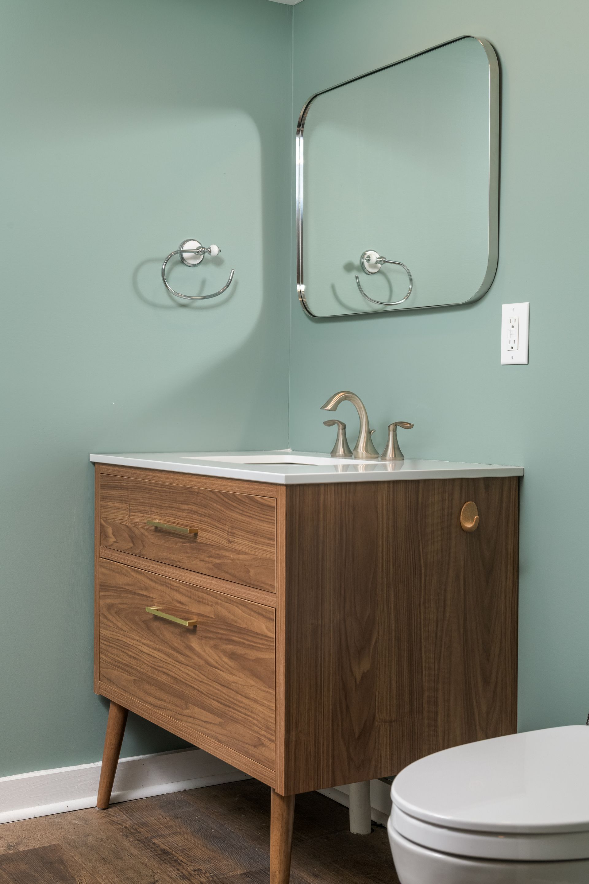 A bathroom with a sink , toilet and mirror.