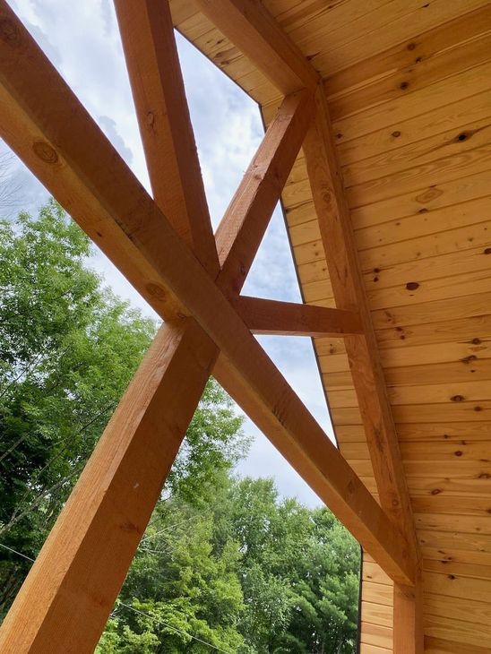 A close up of a wooden structure with trees in the background