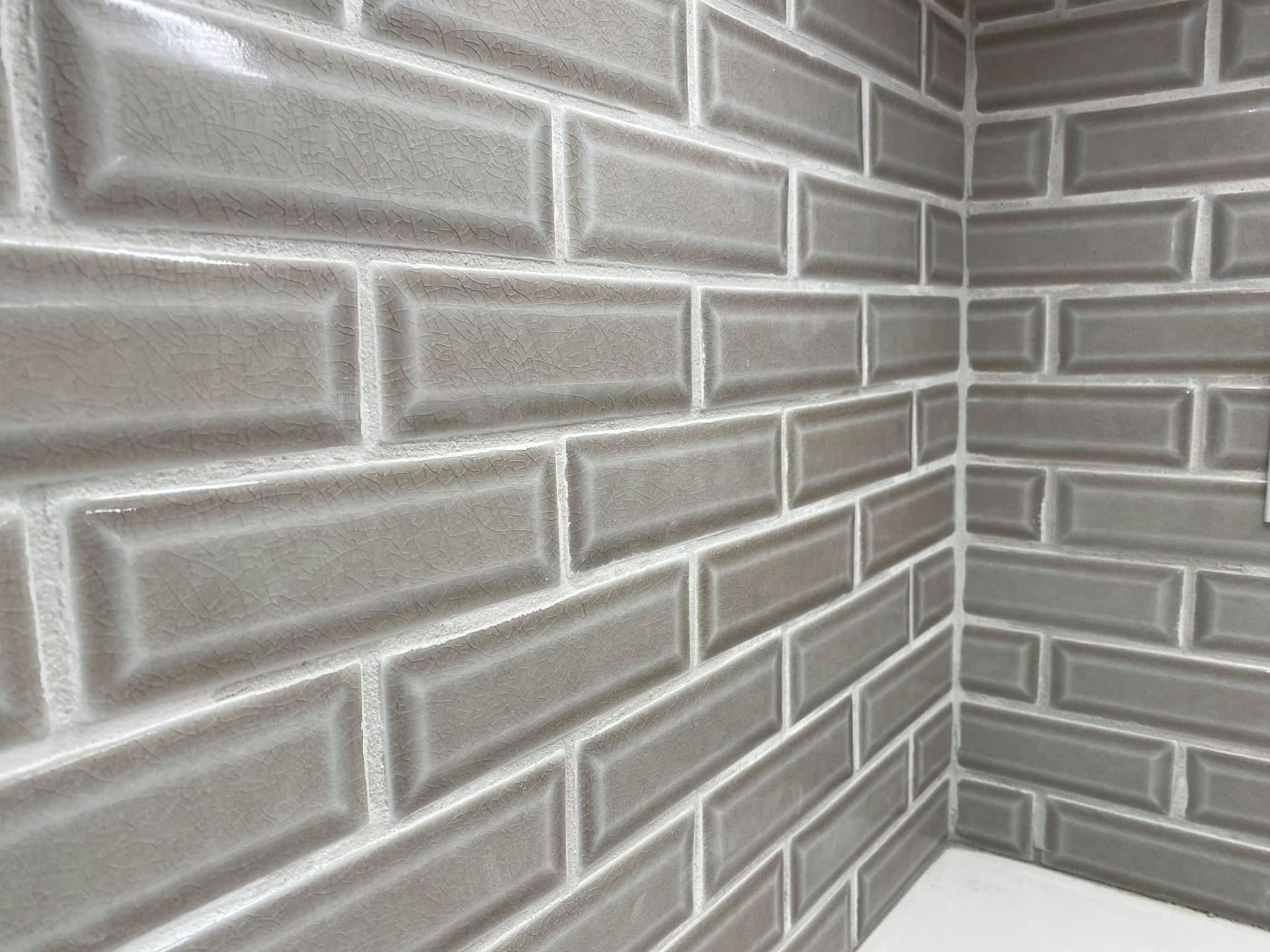 A close up of a gray brick wall in a bathroom.