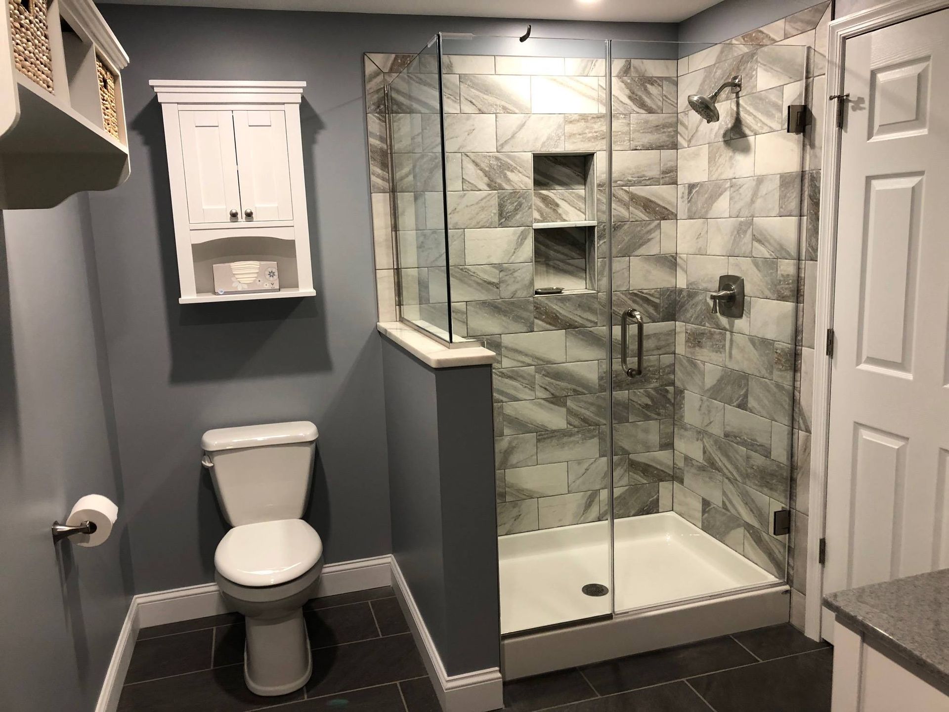 A bathroom with a toilet and a walk in shower.