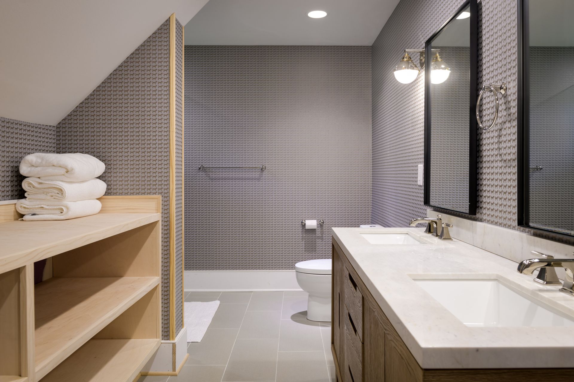 A bathroom with two sinks , a toilet , and a mirror.