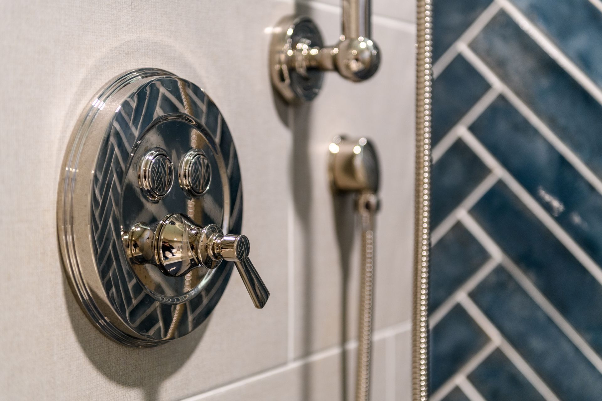 A close up of a shower head and faucet in a bathroom.