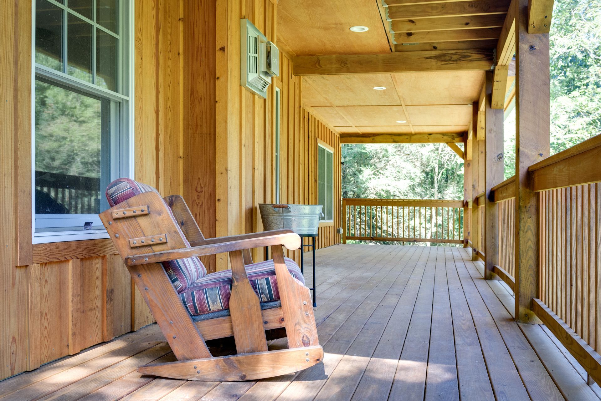 A wooden porch with a rocking chair on it