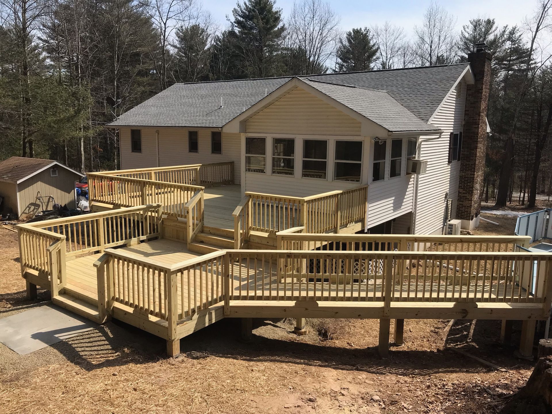 A house with a large wooden deck in front of it