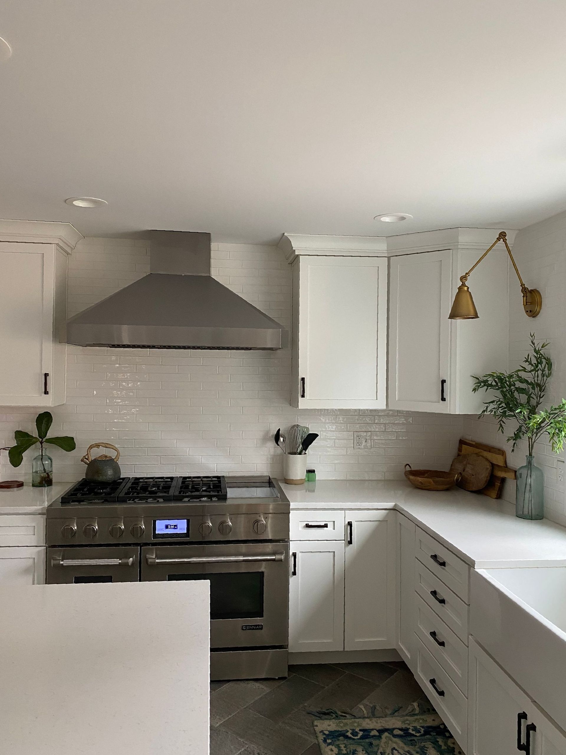 A kitchen with stainless steel appliances and white cabinets