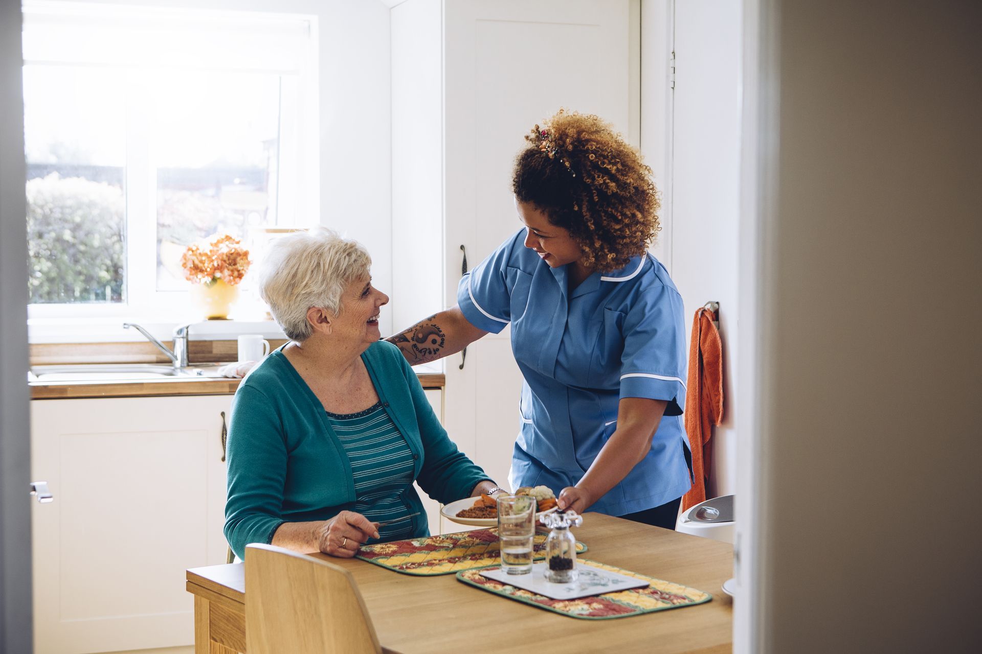 caregiver serving food to her patient