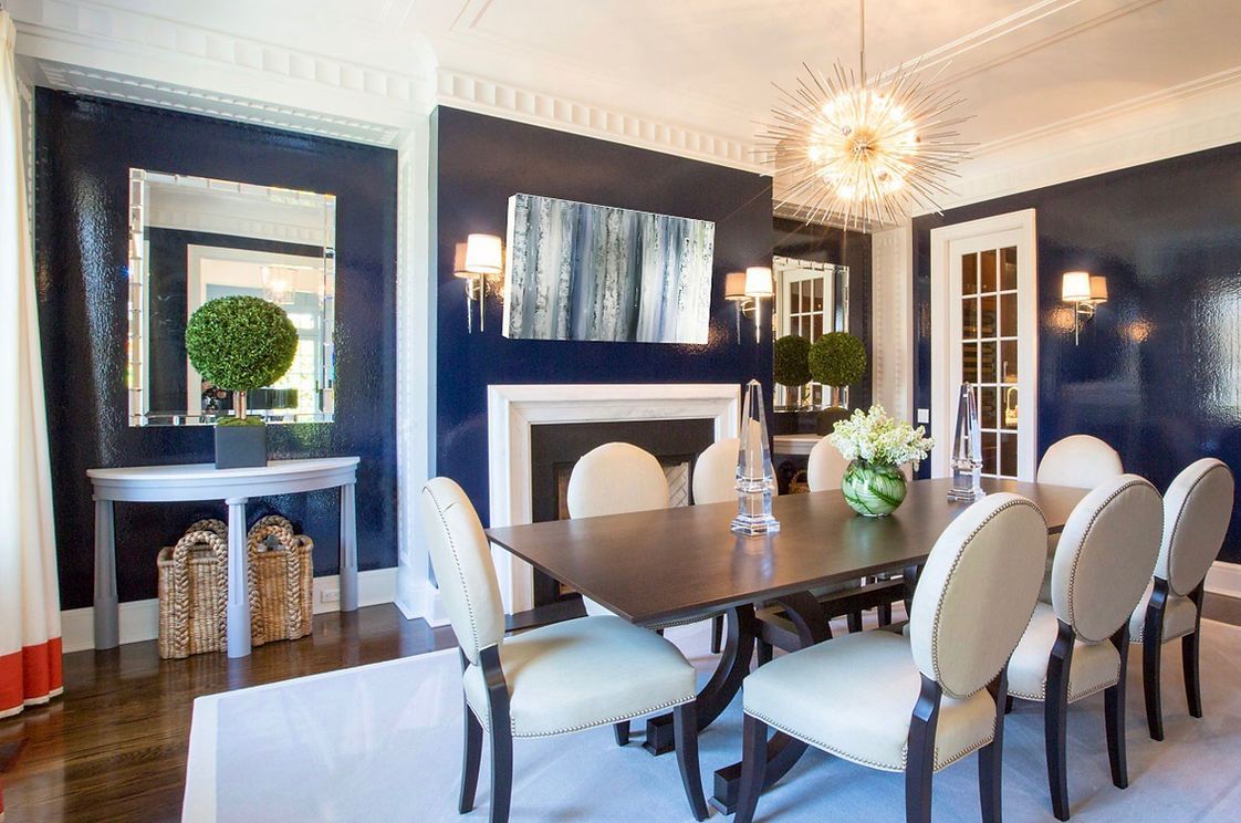 A dining room with a table and chairs and a fireplace.