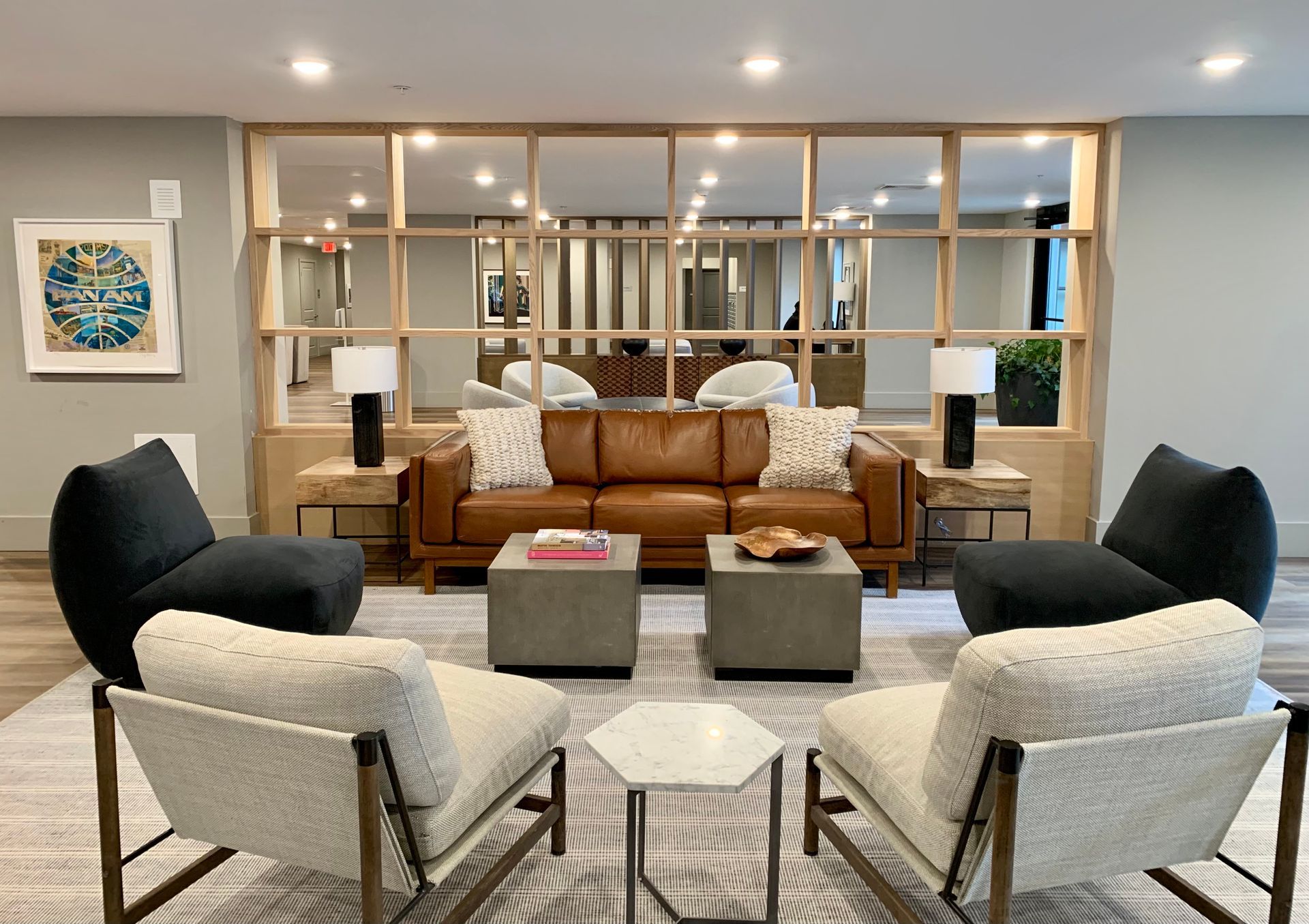 A living room with a couch , chairs , and tables.