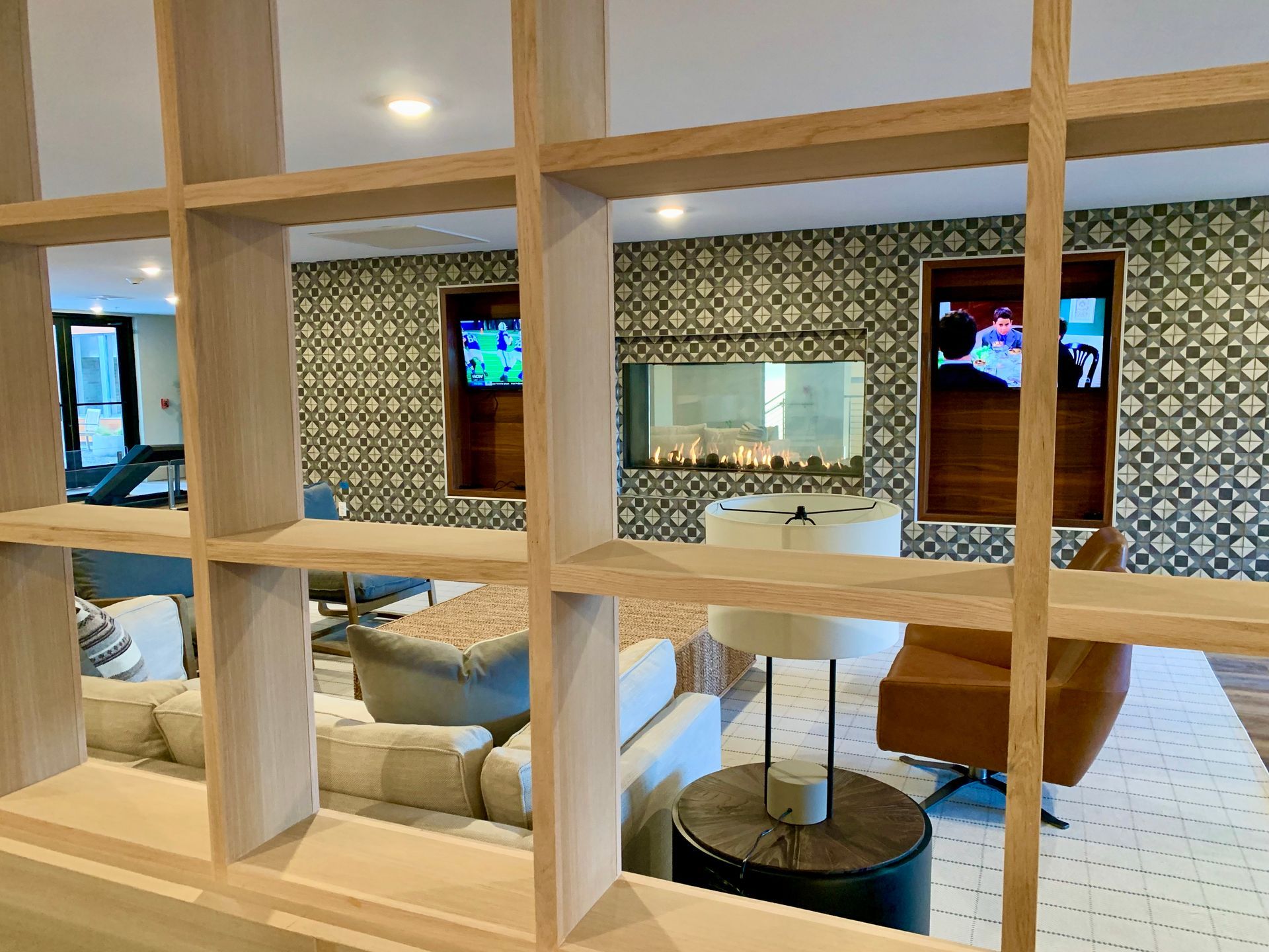 A view of a living room through a wooden shelf.