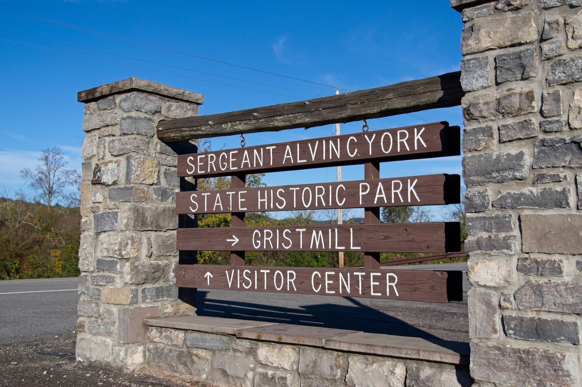 Wooden sign for Sergeant Alvin C. York State Historic Park and Visitor Center against blue sky