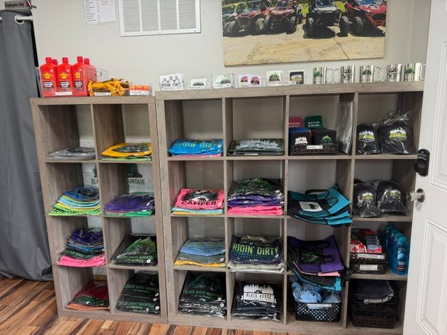 Shelves of folded colorful shirts and packaged items in a store or classroom supply area