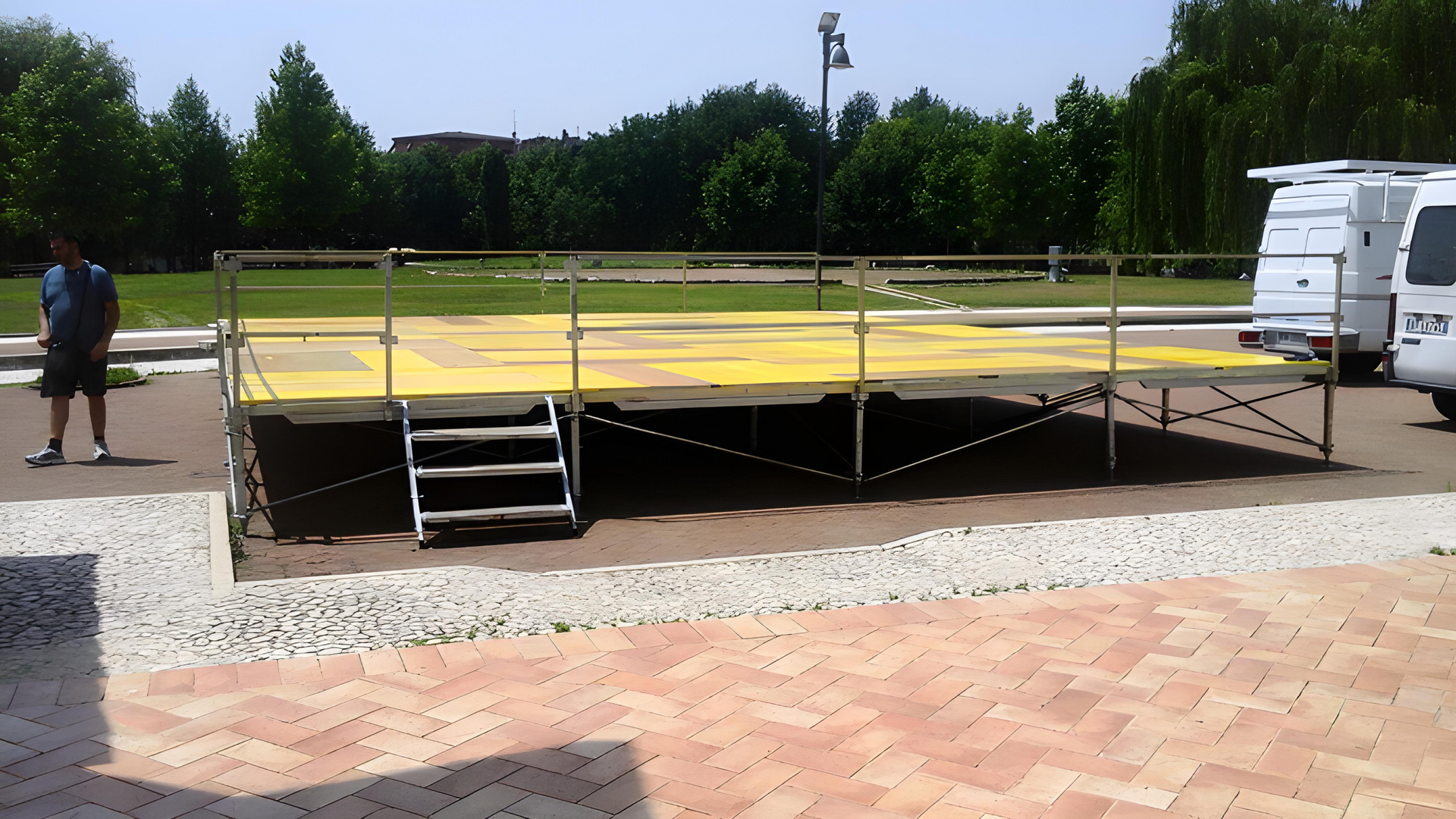 Un uomo è in piedi davanti a un palco in un parco
