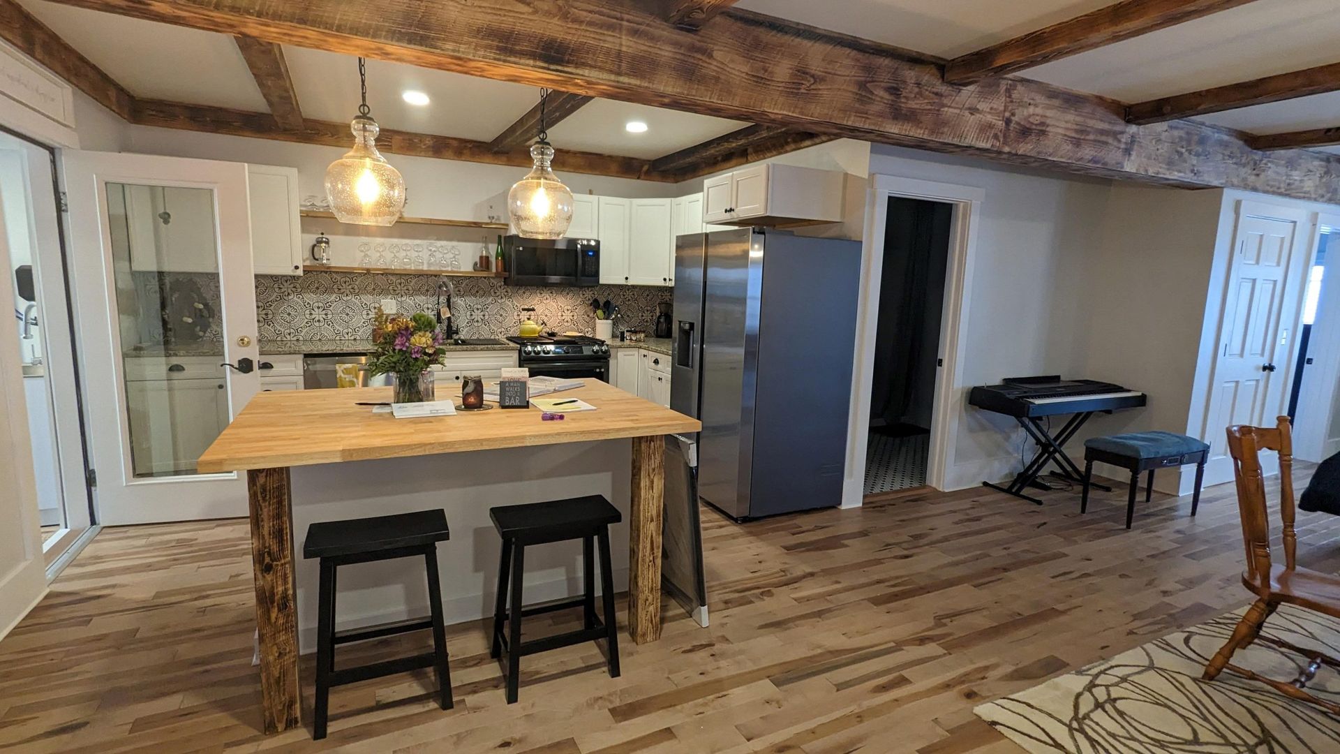 a kitchen remodel with beautiful wood beams, butcher block counters, and maple flooring by Juggernaut Construction Company