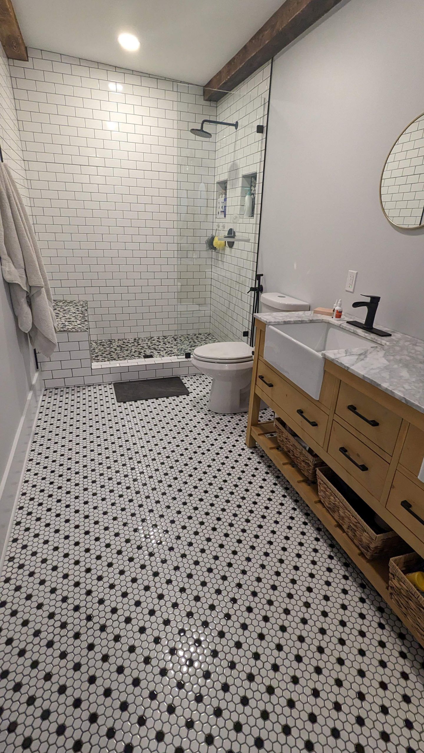 A black and white penny tile bathroom floor expertly installed by Juggernaut Construction
