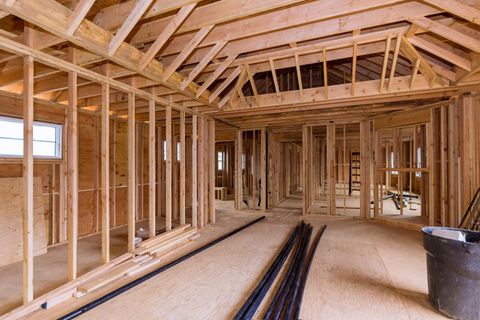 Two construction experts review the site blueprint onsite at a residential remodel