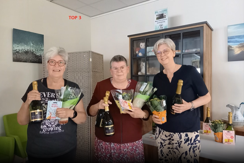 In een goed verlichte ruimte staan ​​drie vrouwen met boeketten en champagneflessen.