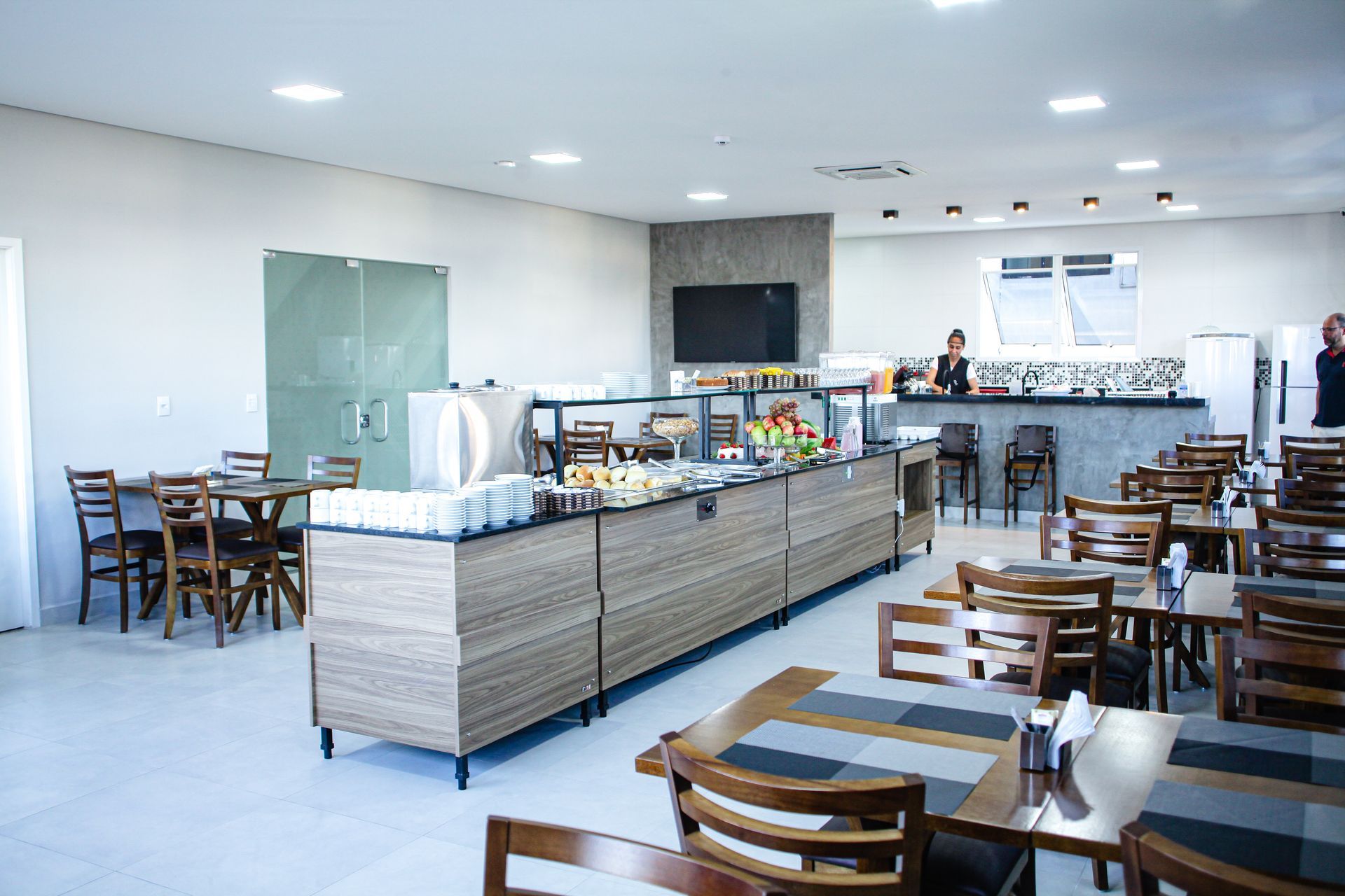 Uma grande sala de jantar com mesas e cadeiras e um bufê. Hotel Solar Paulista