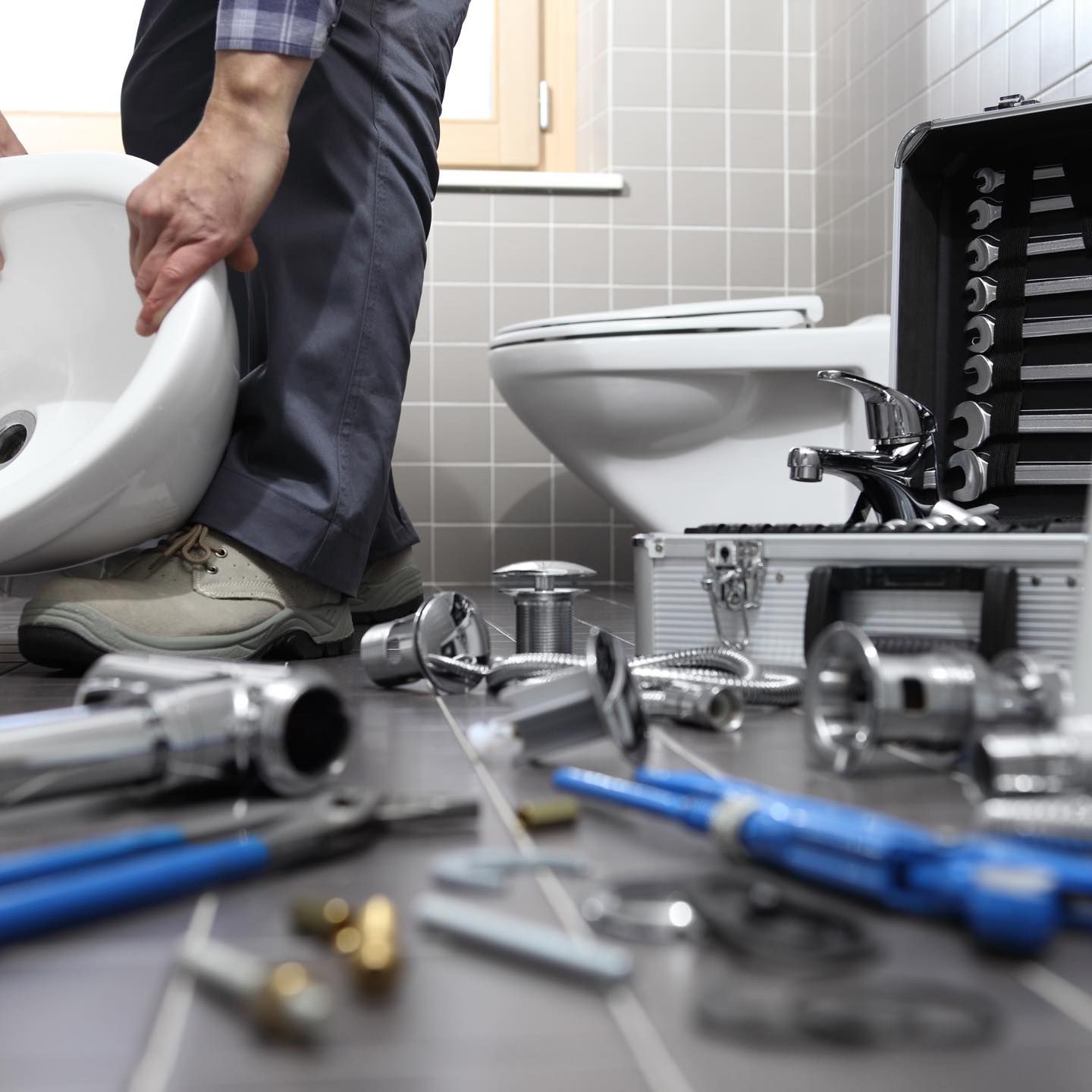 A Plumber is Working on a Toilet in a Bathroom — Wigg Plumbing in Berrimah, NT
