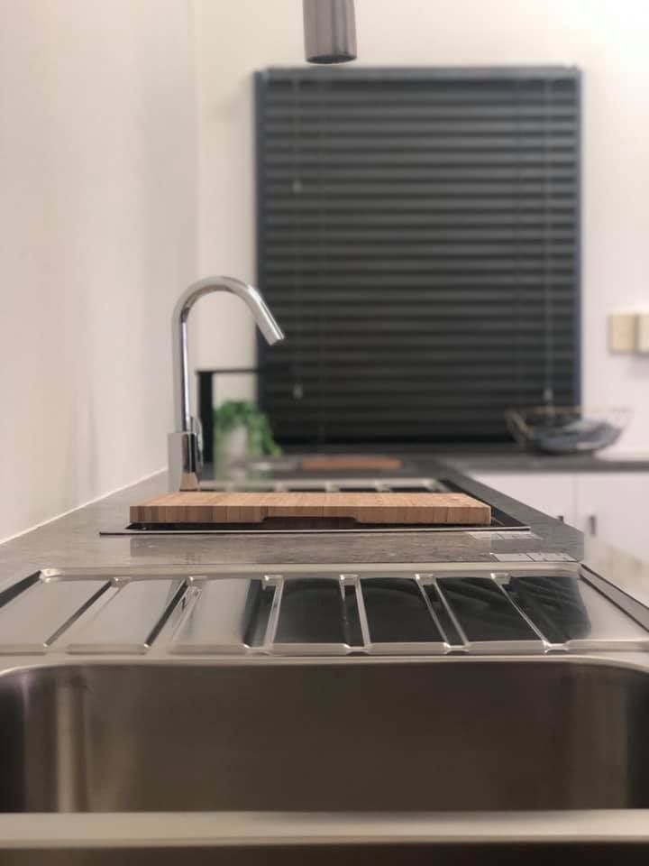A Kitchen Sink With a Faucet and a Cutting Board on Top of It — Wigg Plumbing in Berrimah, NT