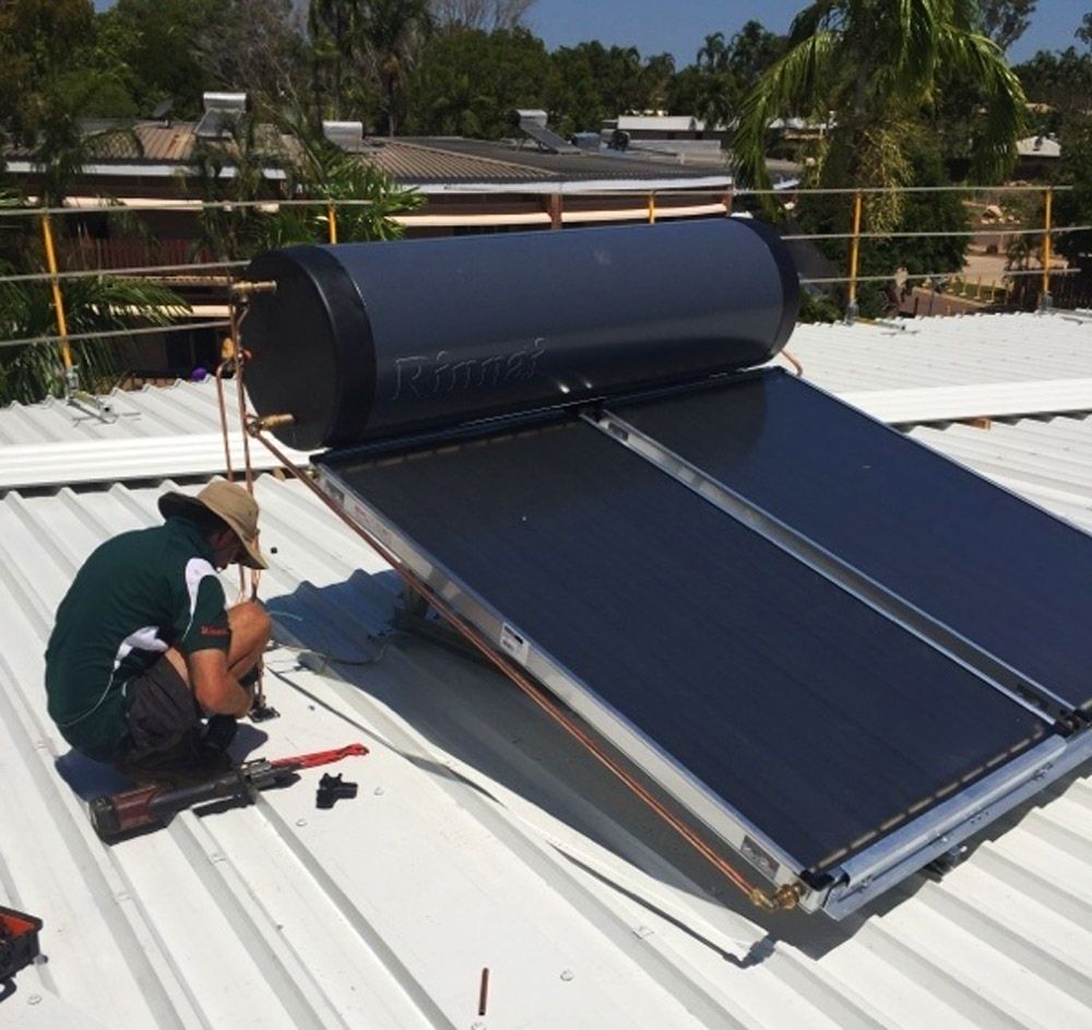 Male Plumber Repairing A Solar Hot Water System 