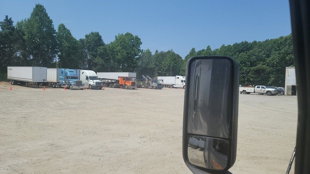 A truck is parked in a lot with a lot of trucks in the background.