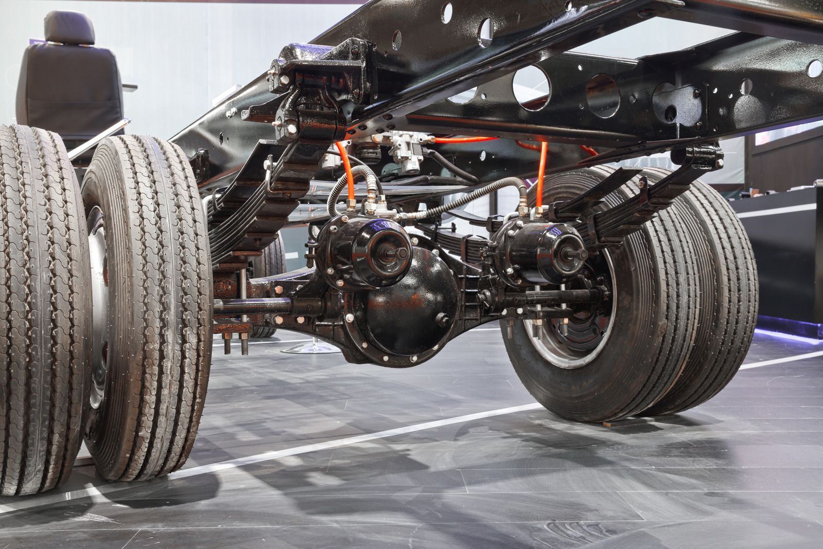 A close up of a truck 's suspension and tires.